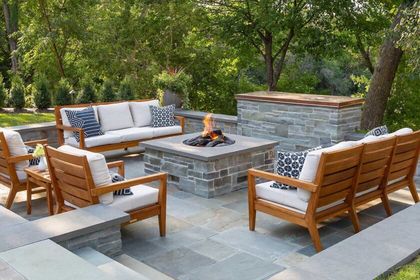 Sunken bluestone firepit and television area in garden with teak furniture. creative design landscapes