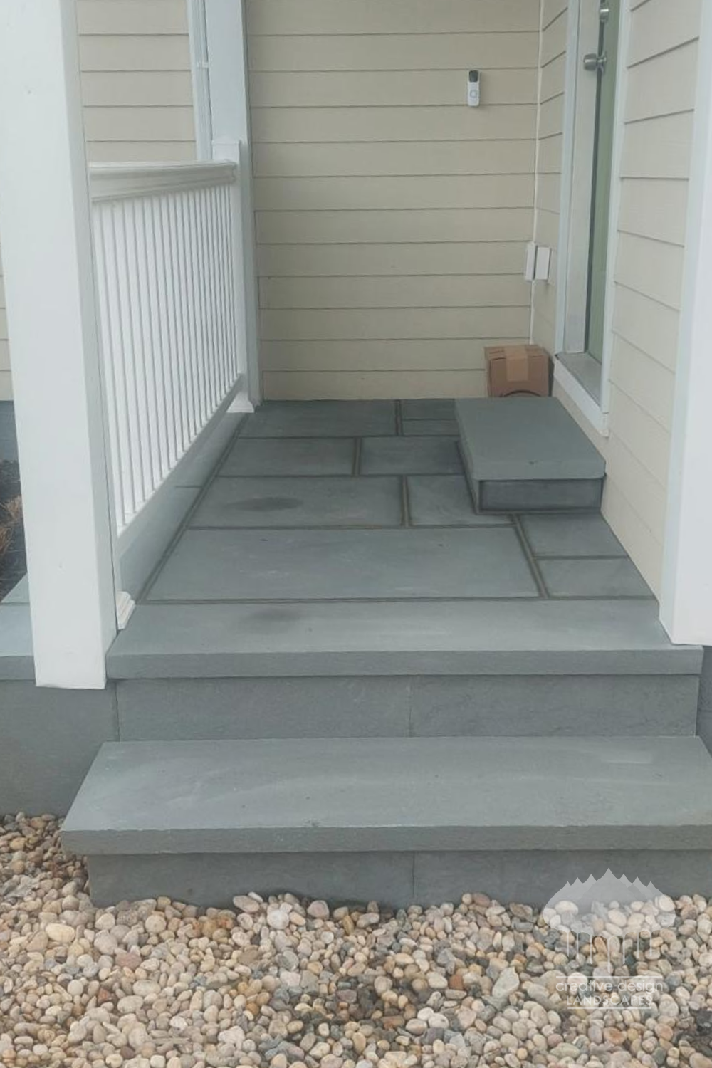Bluestone entry steps and landing with a clean gravel border at a home entrance
